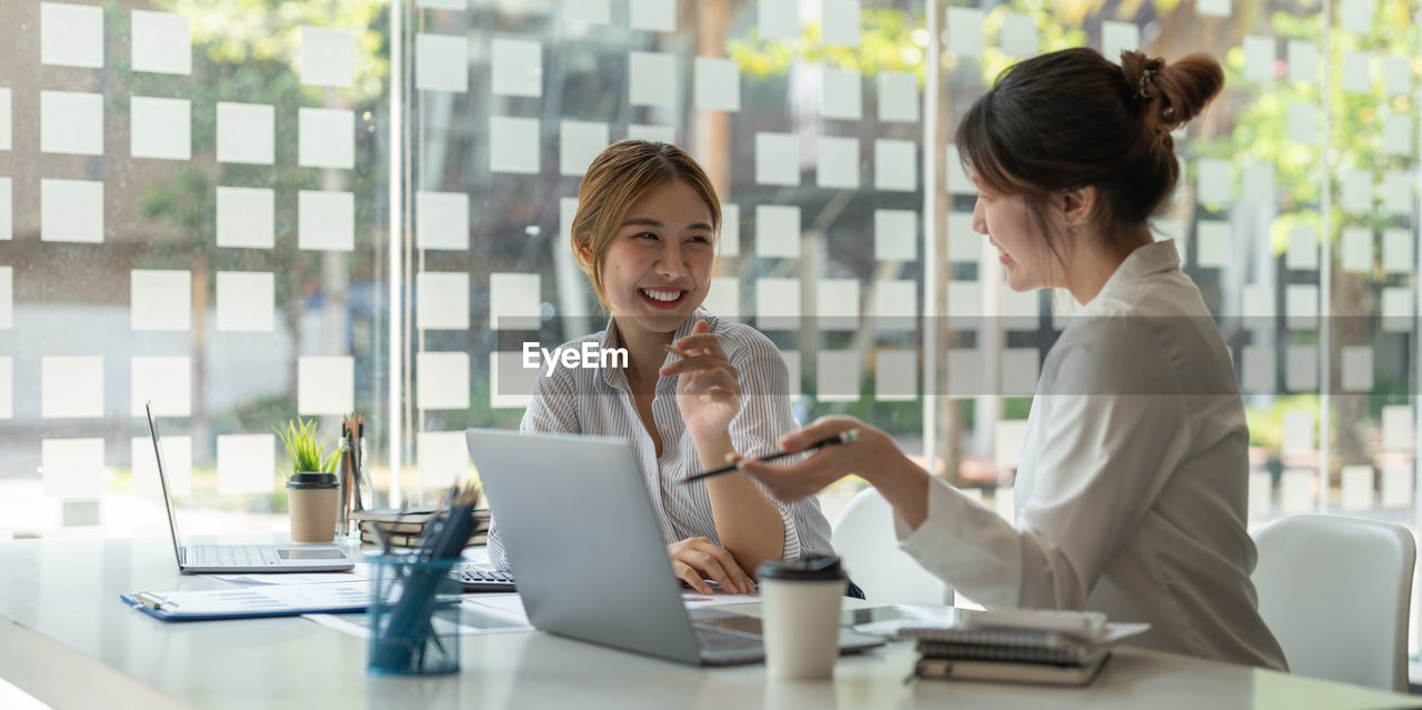 Smiling businesswomen brainstorming at office