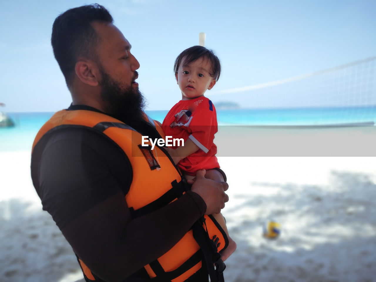 Man carrying baby girl at beach