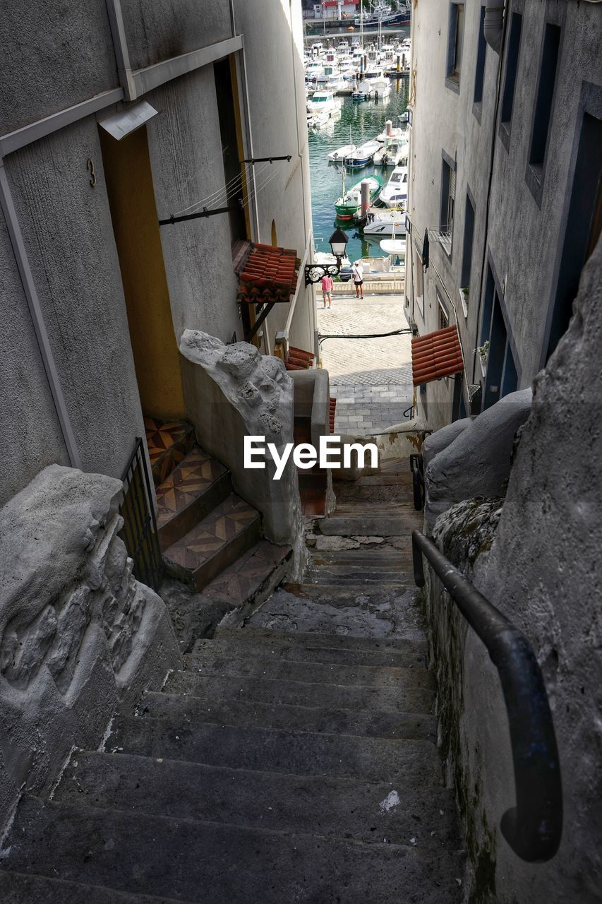 HIGH ANGLE VIEW OF ALLEY AMIDST BUILDINGS