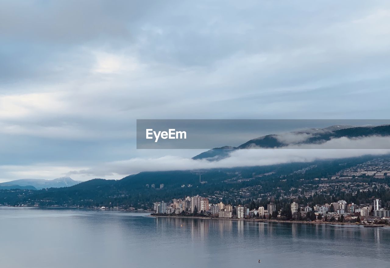 Scenic view of sea by city against sky