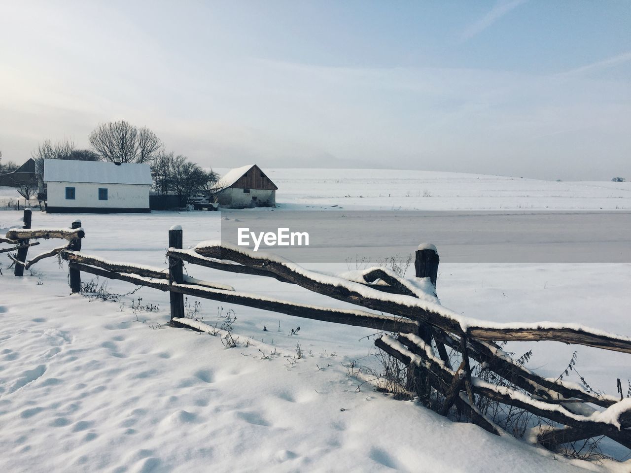 Scenic view of snow covered field against sky