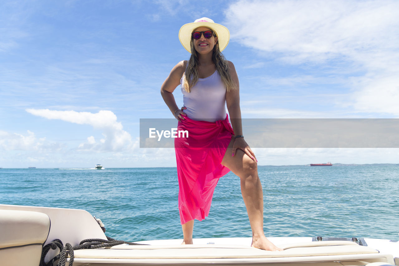 A woman on top of a boat against the sea in the background. salvador, bahia, brazil.