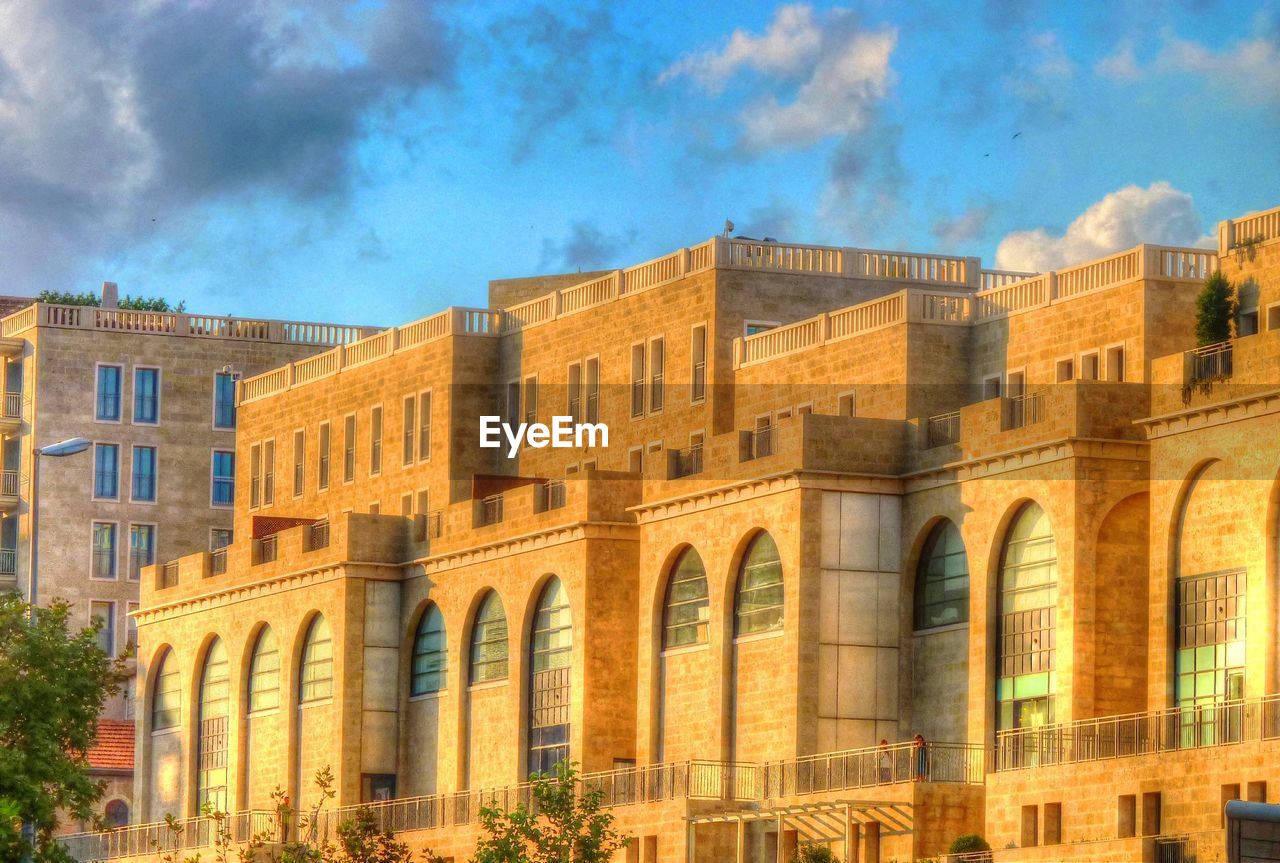 LOW ANGLE VIEW OF BUILDINGS AGAINST CLOUDY SKY