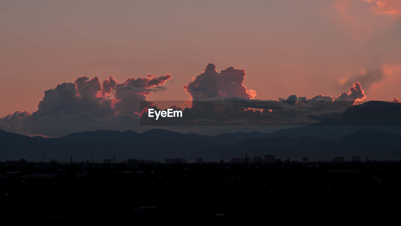 SCENIC VIEW OF SILHOUETTE MOUNTAINS AGAINST DRAMATIC SKY