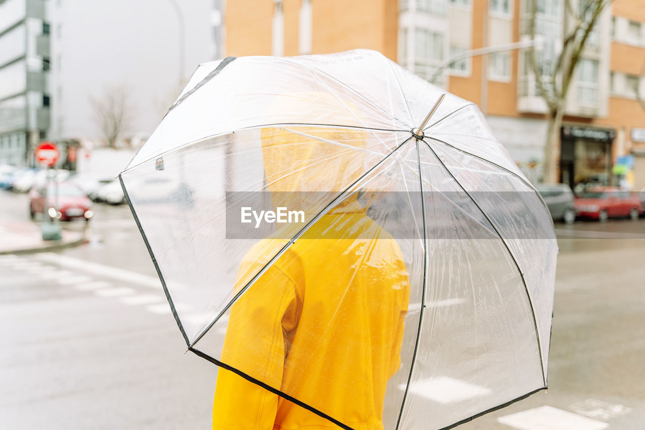 Woman walking with umbrella at street