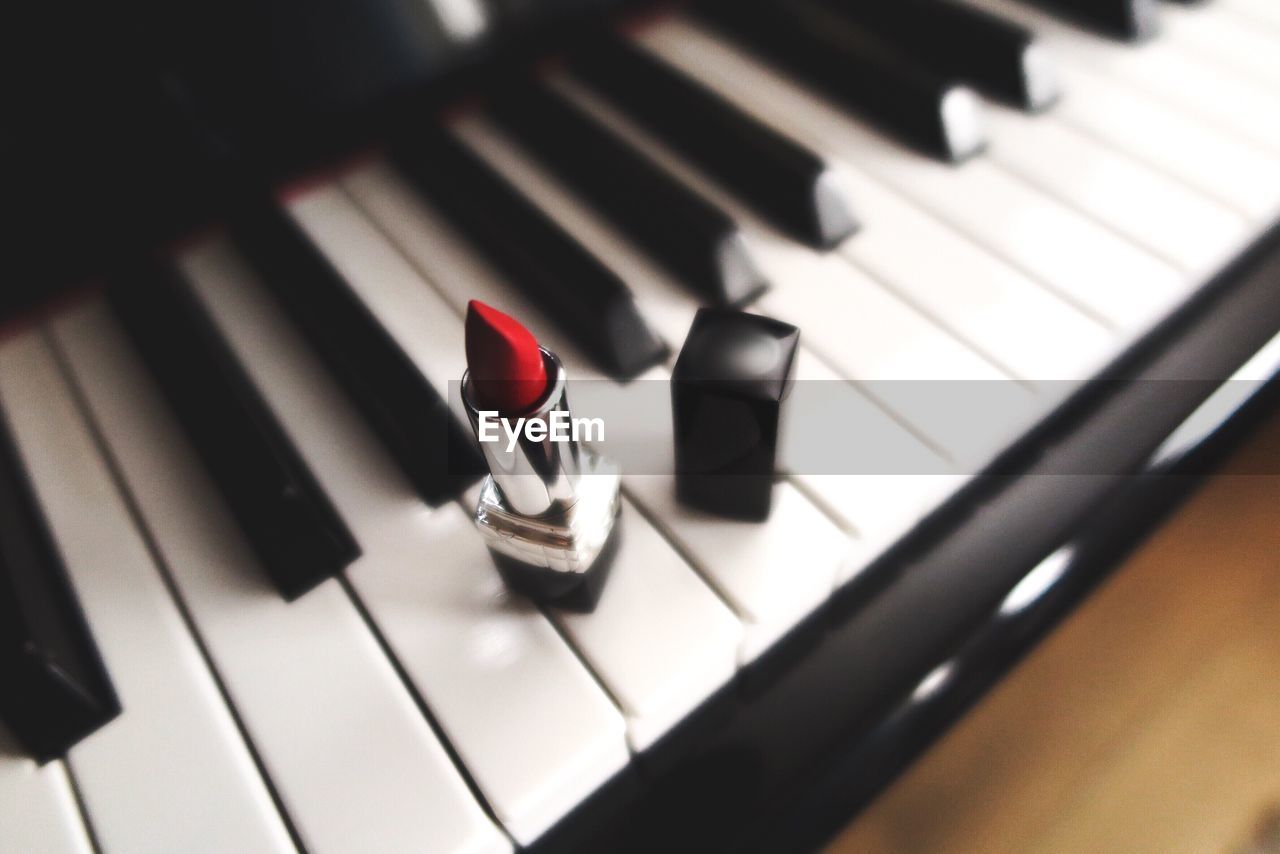 High angle view of red lipstick on piano keys
