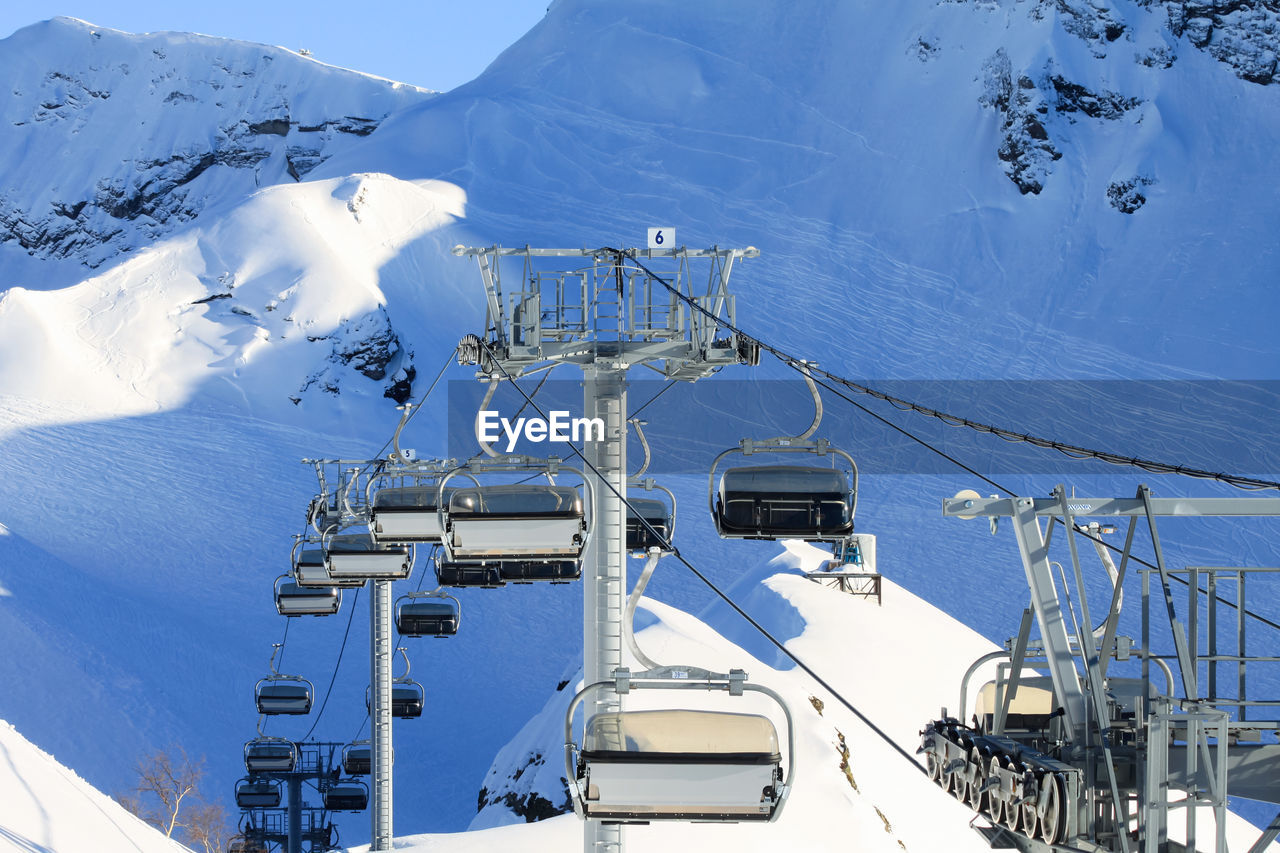 An empty chairlift cabin. in the background snowy slopes with traces of fans of off-piste skiing.