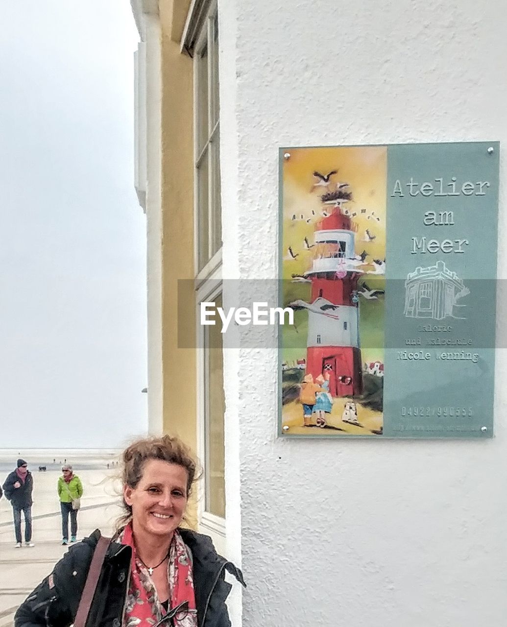 PORTRAIT OF HAPPY WOMAN AGAINST BUILDING IN CITY