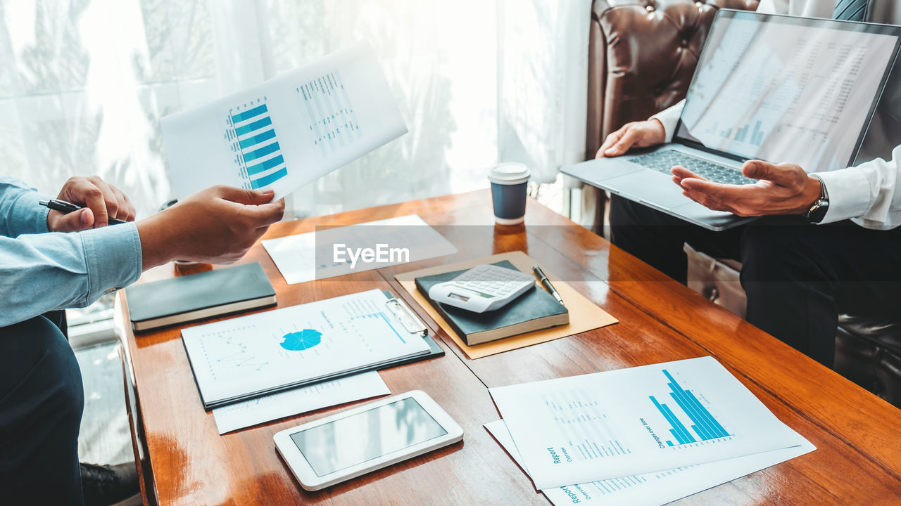 Cropped image of business colleagues working at desk in office