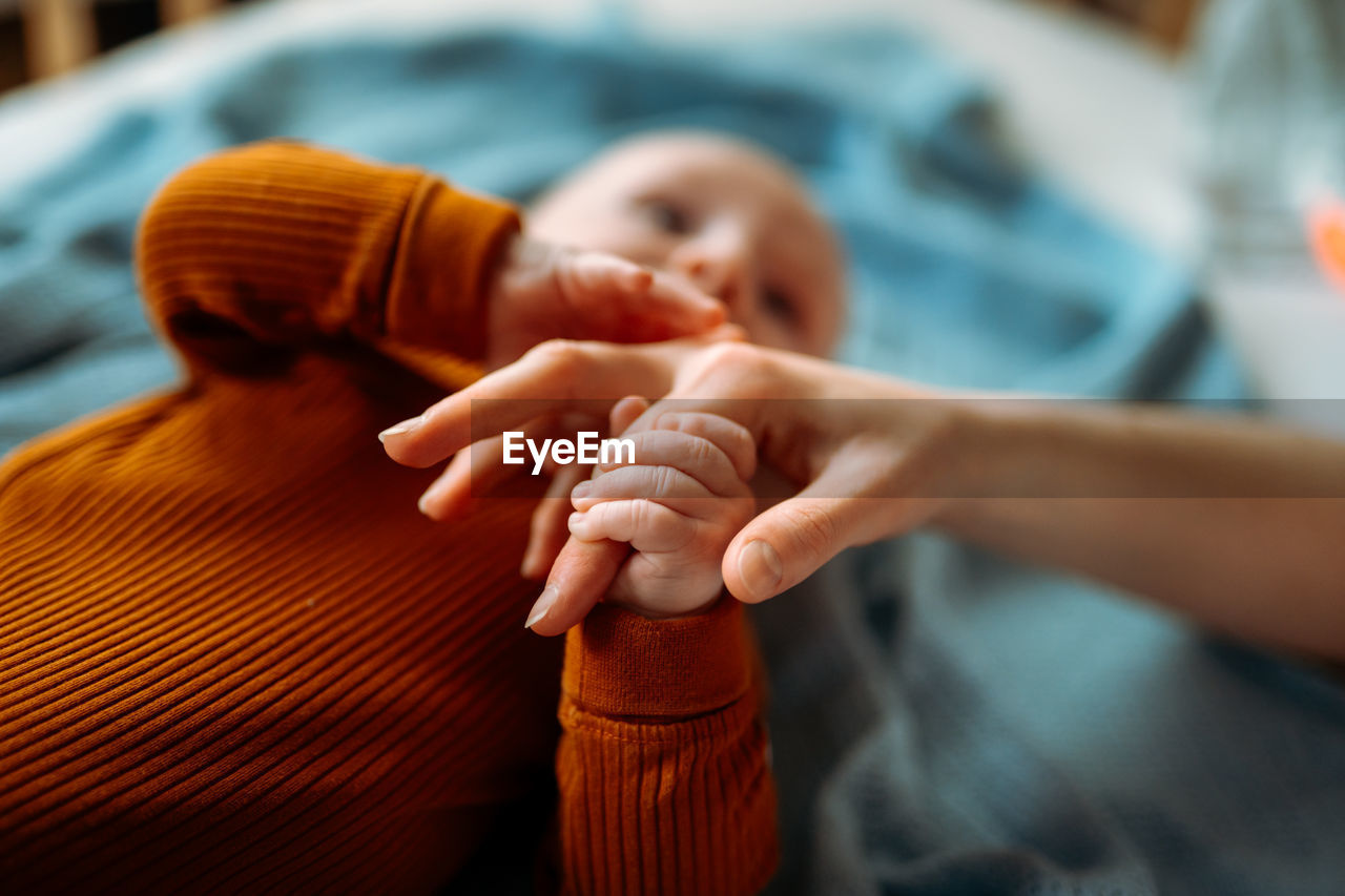 Baby toddler holding mother's hand. holding hand of newborn child