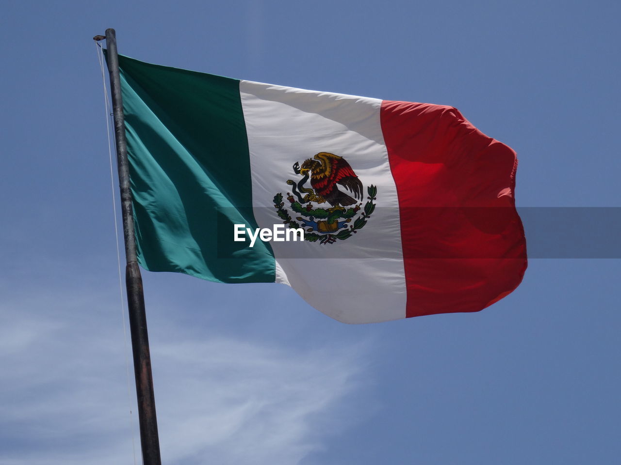 Low angle view of mexican flag against blue sky