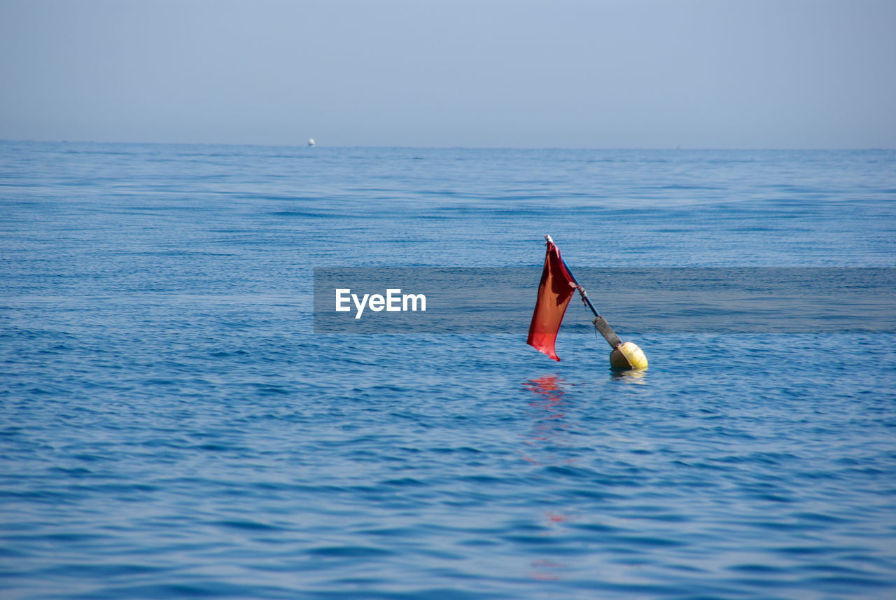 Buoy in sea against sky