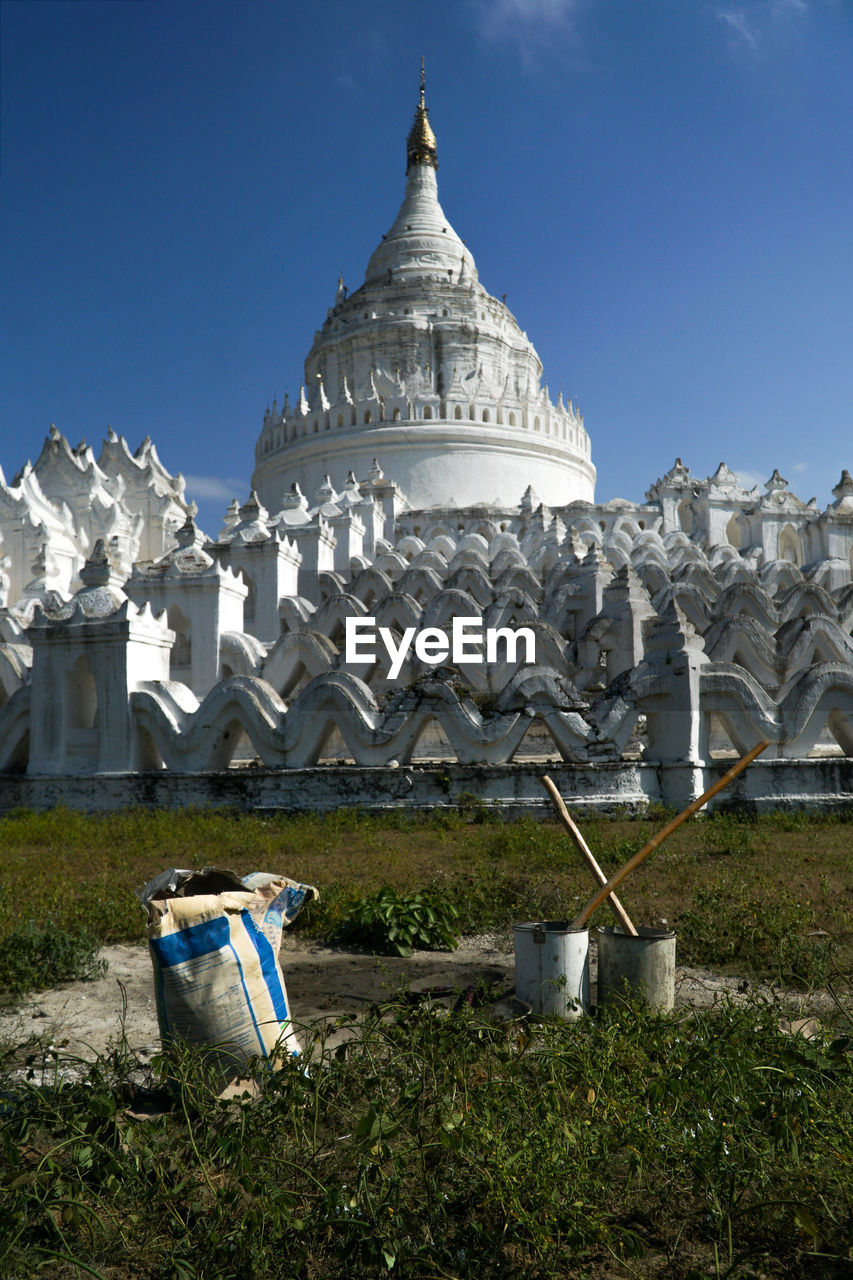 Low angle view of traditional construction material in front mingun pagoda against blue sky