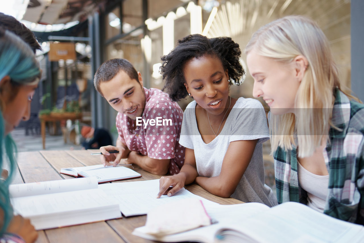 Cheerful friends studying at campus