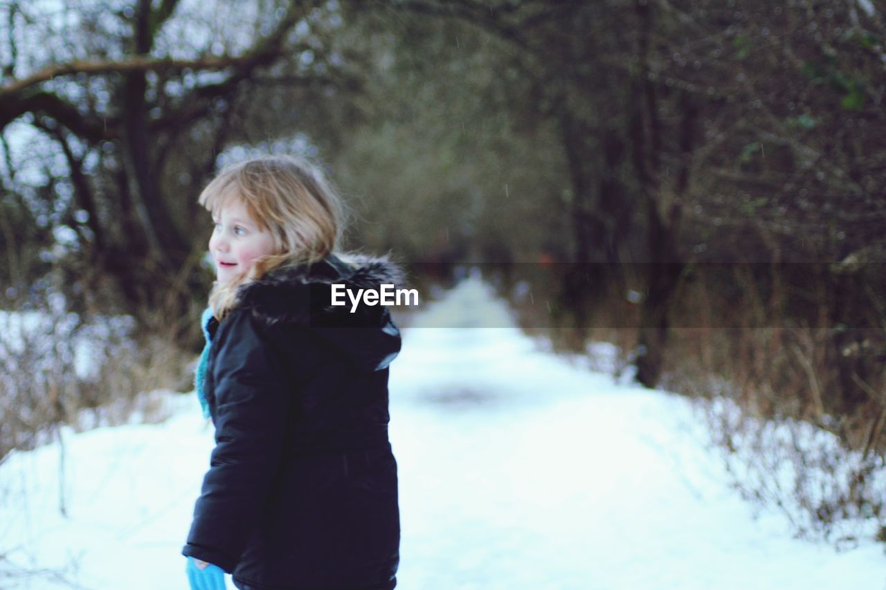 Rear view of girl standing in snow