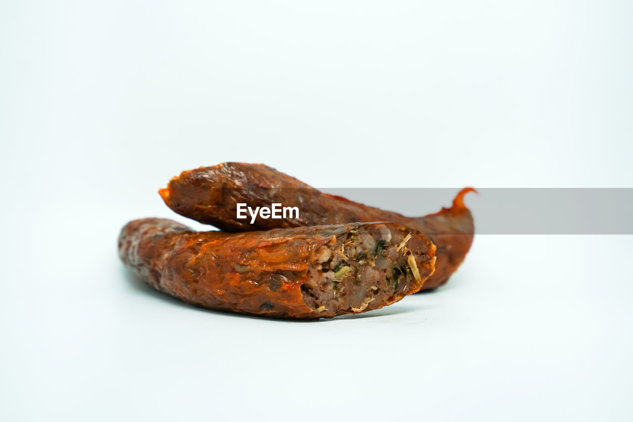 CLOSE-UP OF MEAT AGAINST WHITE BACKGROUND