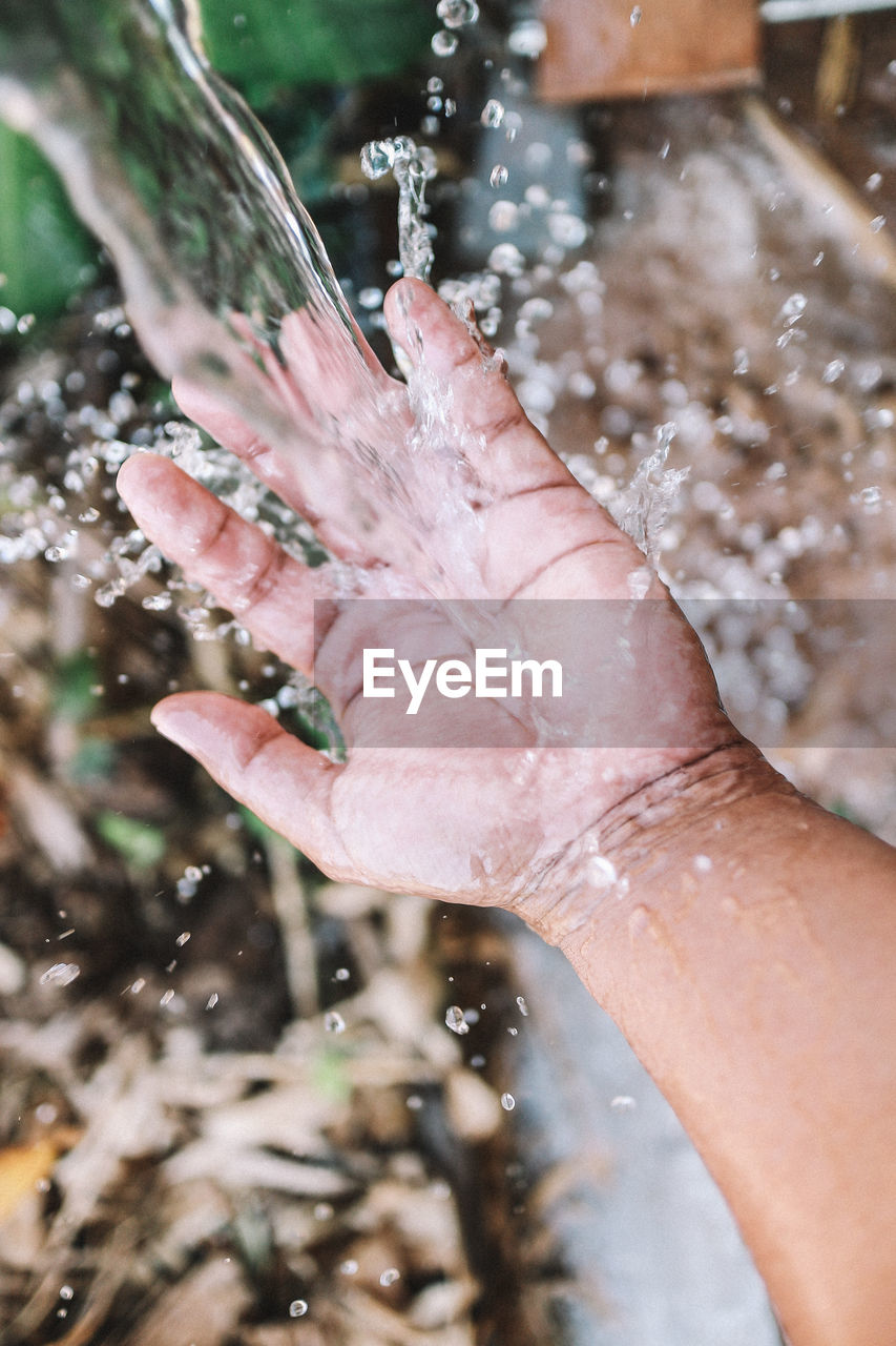 Close-up of hand holding water splashing