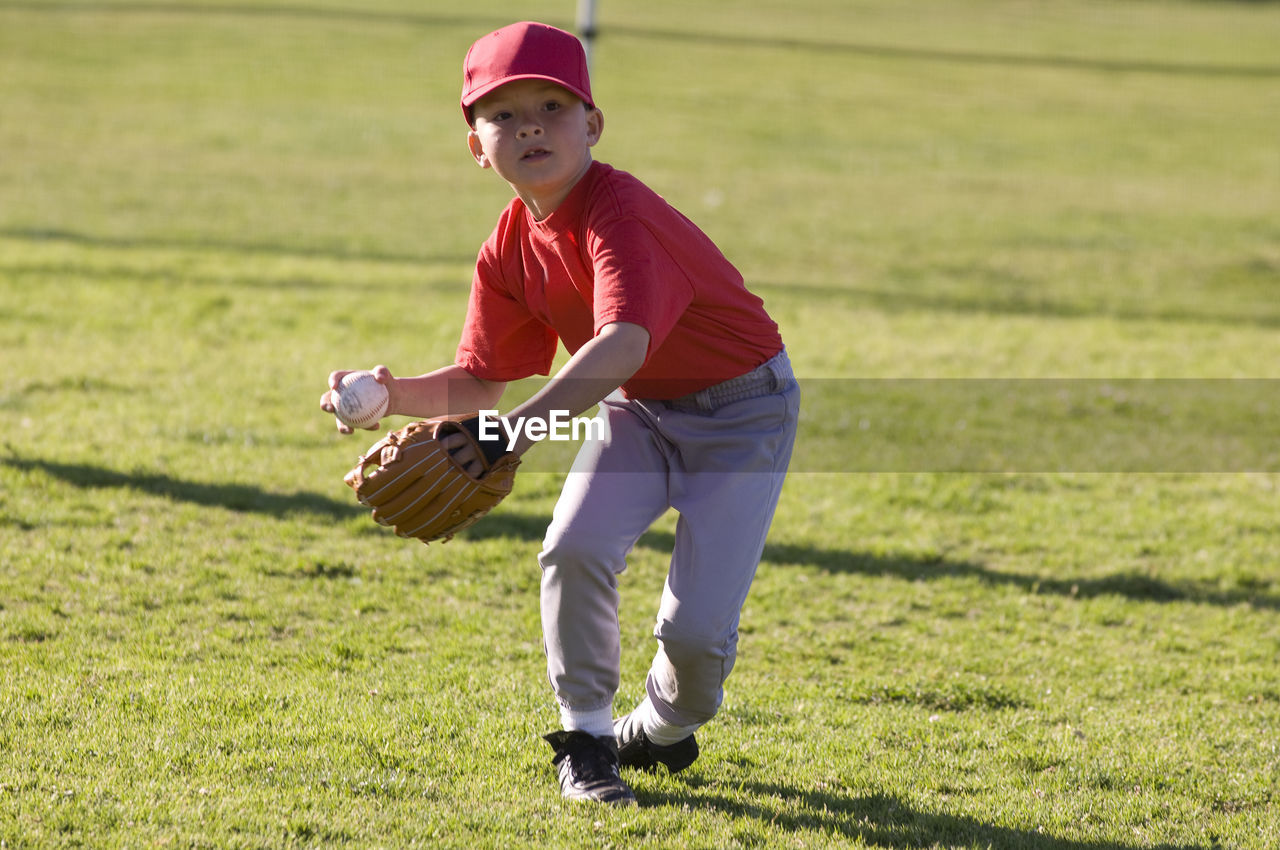 Young boy fielding a baseball during tball game