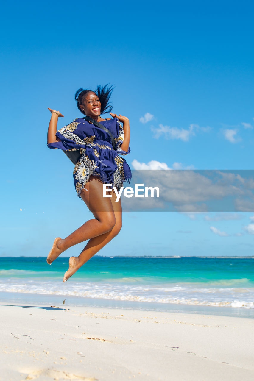 Full length of woman jumping on beach