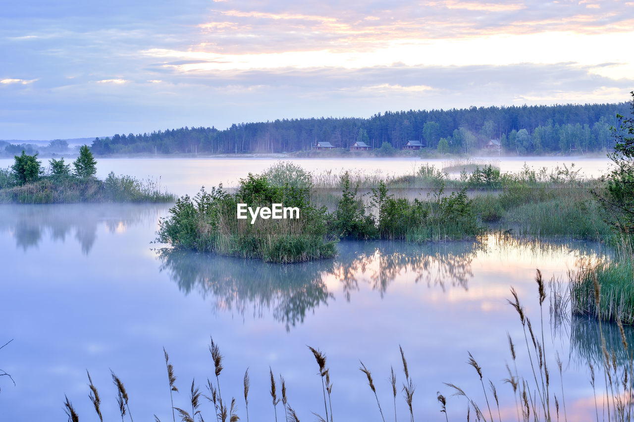 SCENIC VIEW OF LAKE AGAINST SKY AT SUNSET