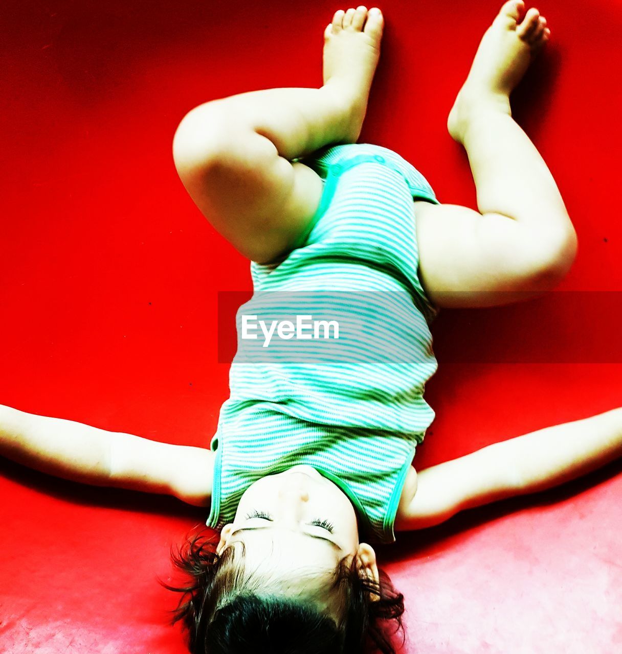 PORTRAIT OF A GIRL SITTING ON TILED FLOOR