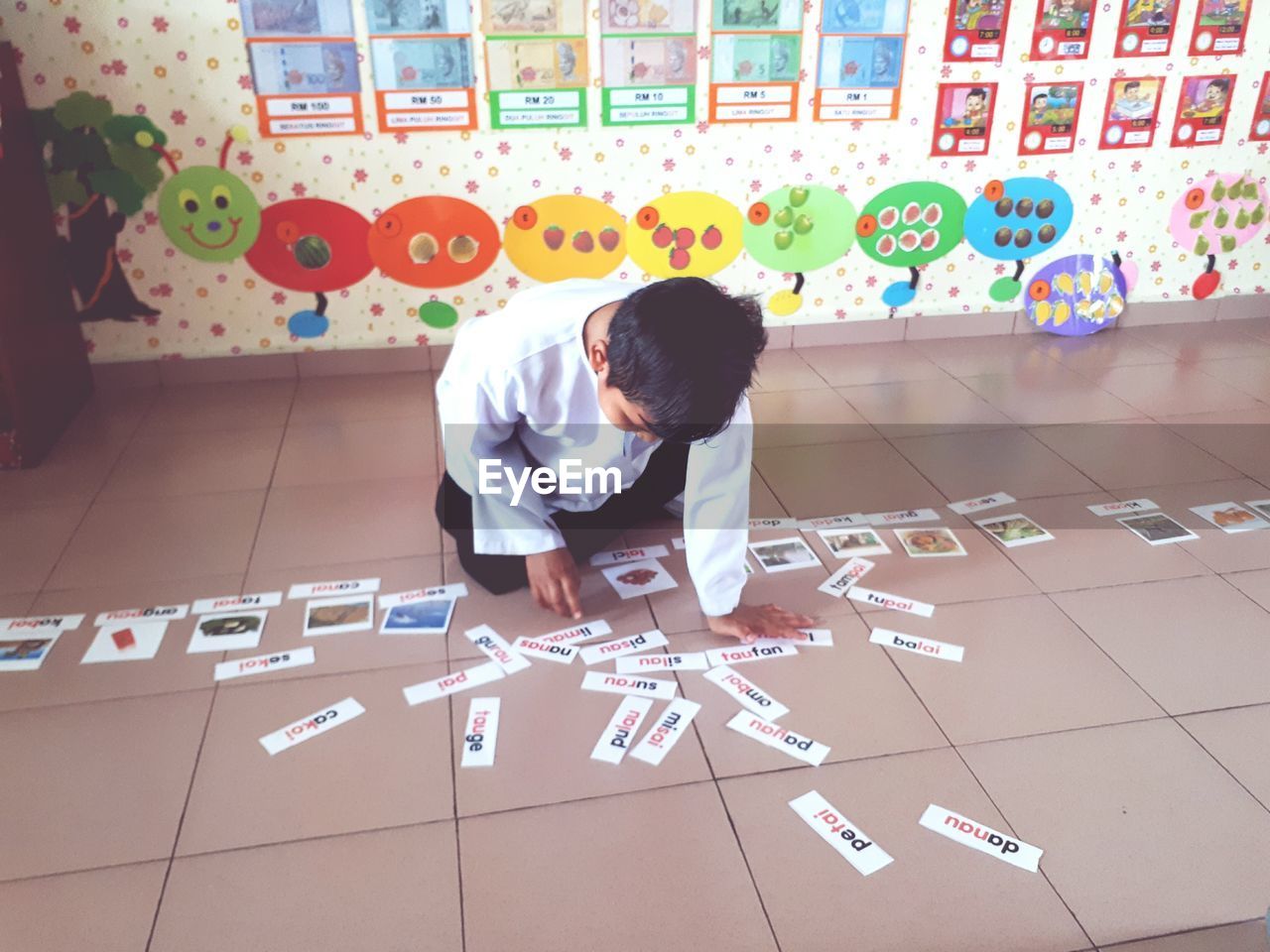 FULL LENGTH OF BOY PLAYING WITH PAPER