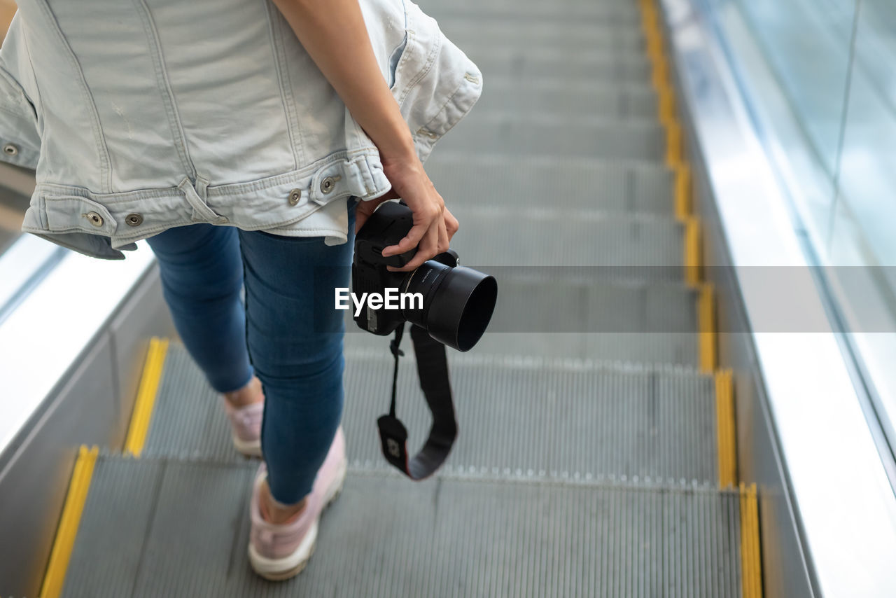 Low section of woman standing on staircase