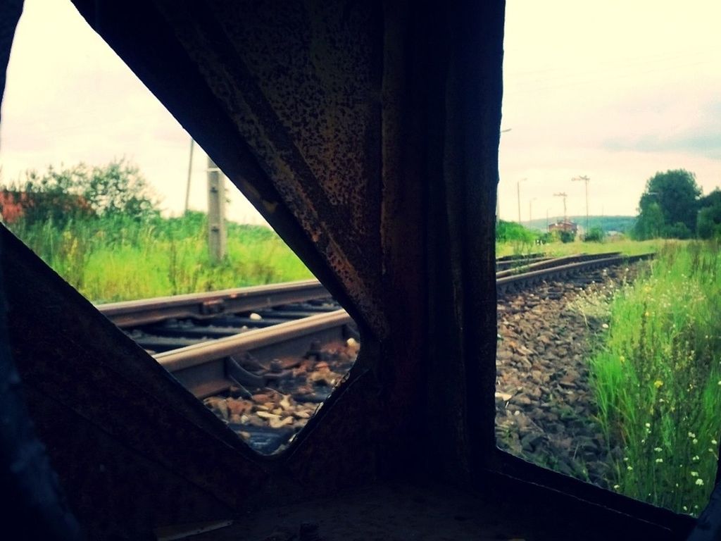 Railroad track seen through metallic structure against sky