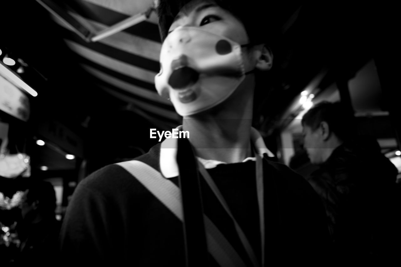 CLOSE-UP OF MAN WEARING MASK STANDING IN BATHROOM