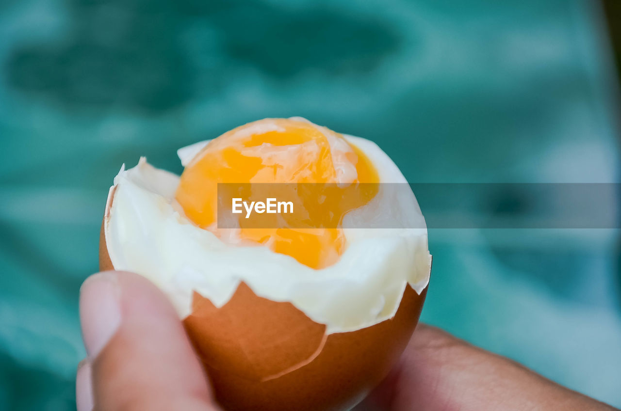 Close-up of hand holding a boiled egg 