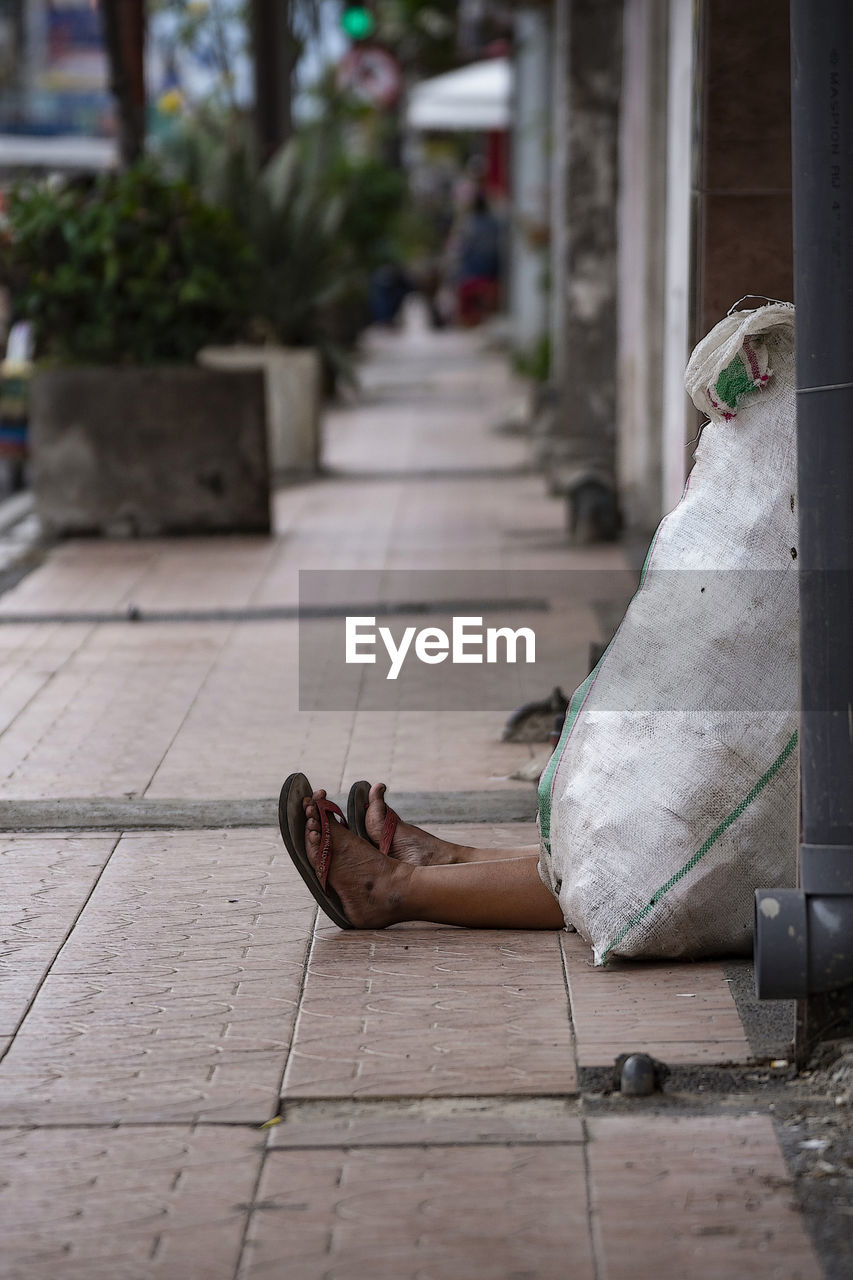 Woman relaxing on sidewalk in city