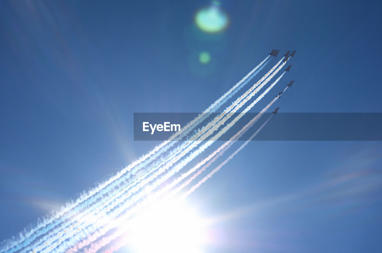 LOW ANGLE VIEW OF AIRCRAFT WING AGAINST BLUE SKY