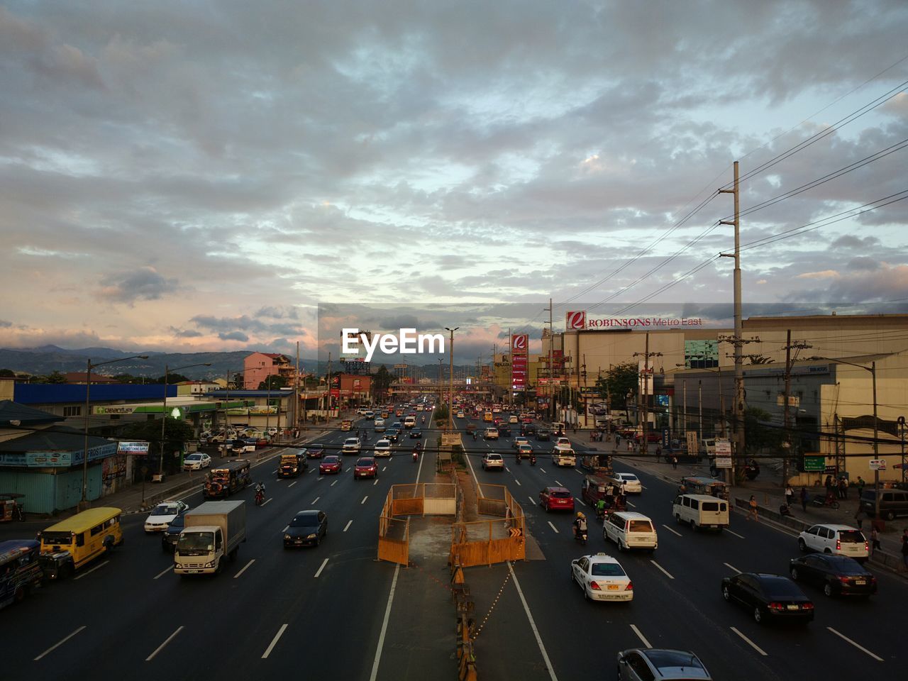 HIGH ANGLE VIEW OF TRAFFIC ON ROAD AT SUNSET