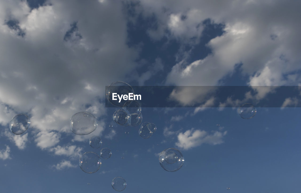 LOW ANGLE VIEW OF BUBBLES AGAINST SKY AT NIGHT