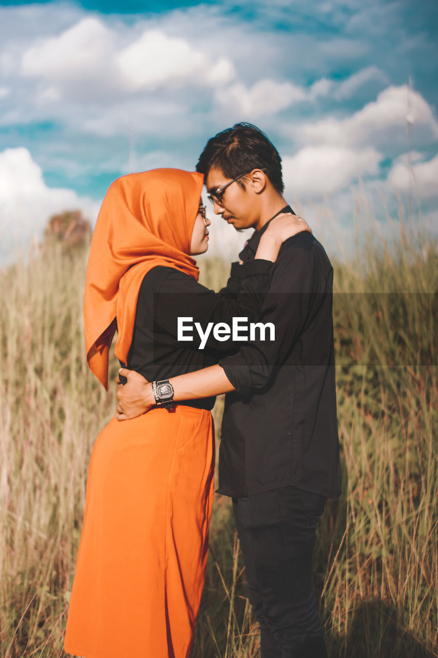 Young couple standing on field