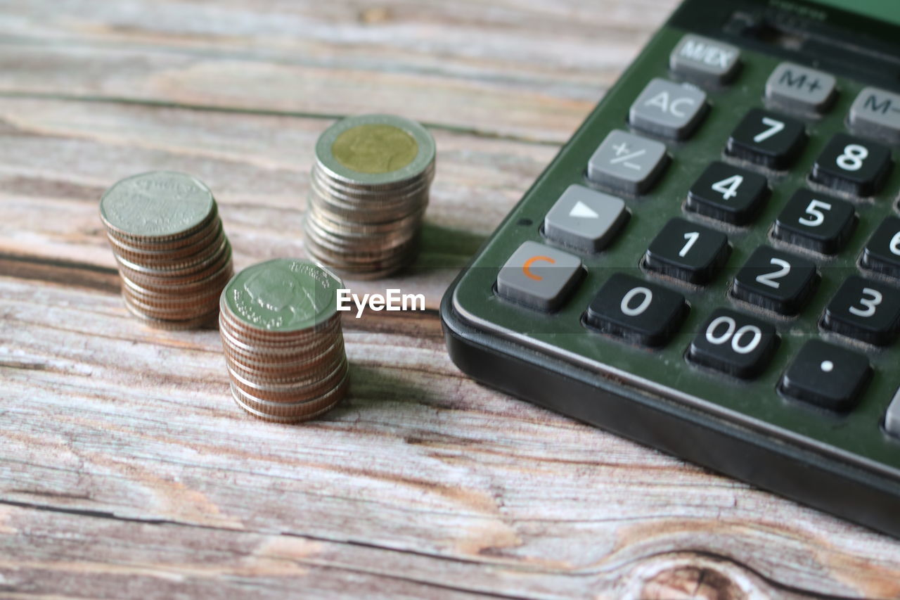 CLOSE-UP OF COINS ON WOODEN TABLE