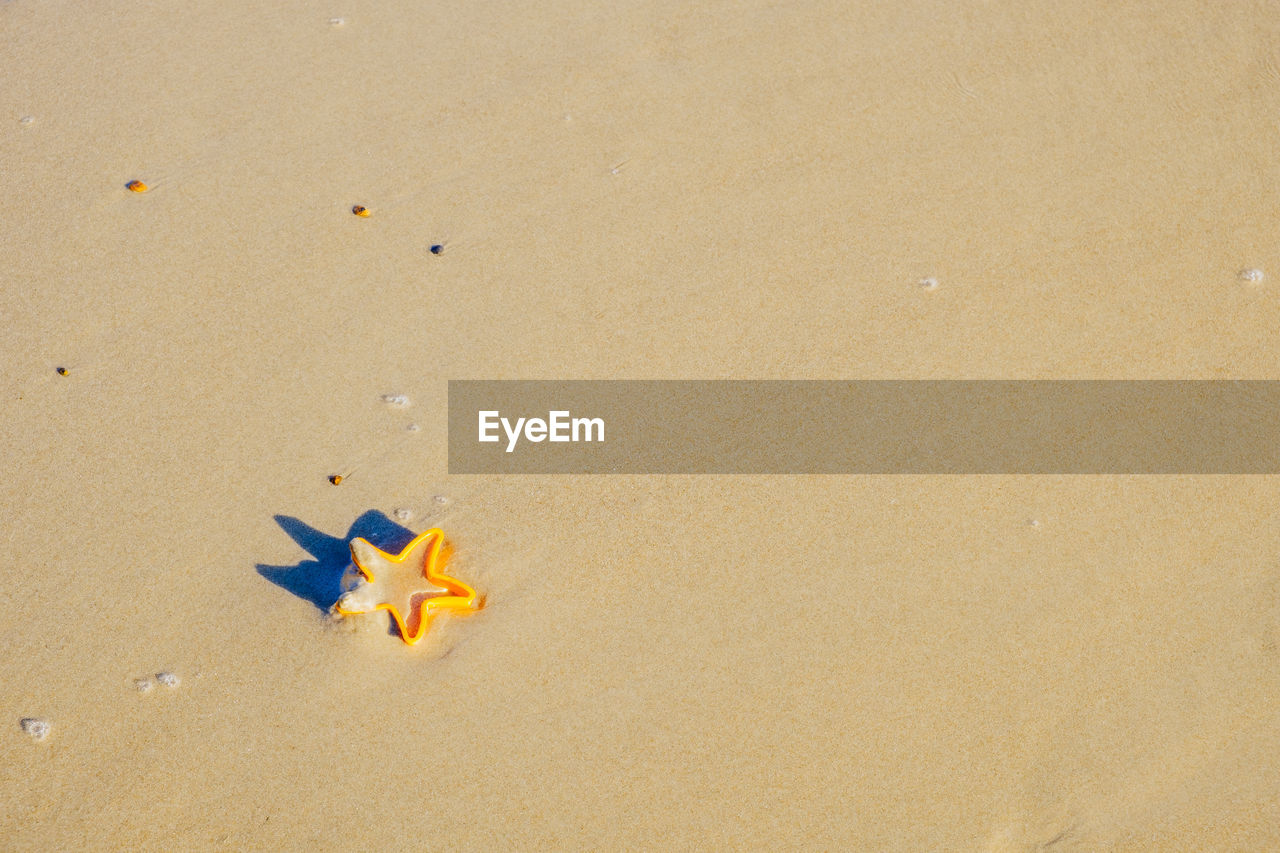 High angle view of yellow toy on beach