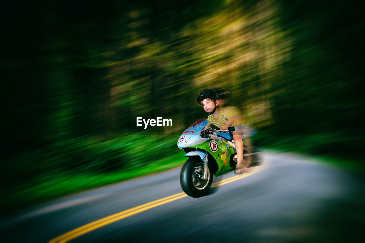 Boy riding bicycle on road