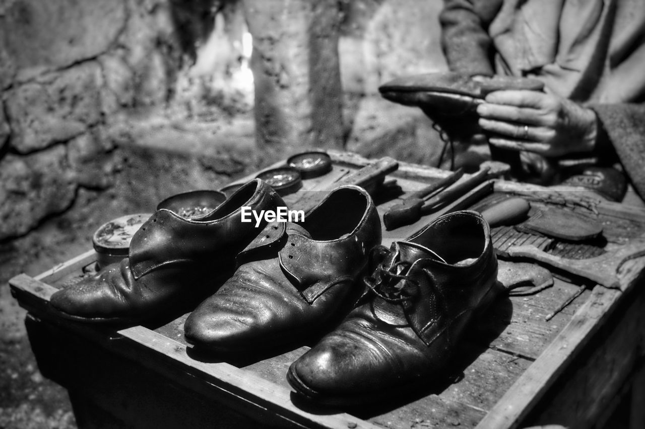 Midsection of shoemaker repairing shoe at workshop