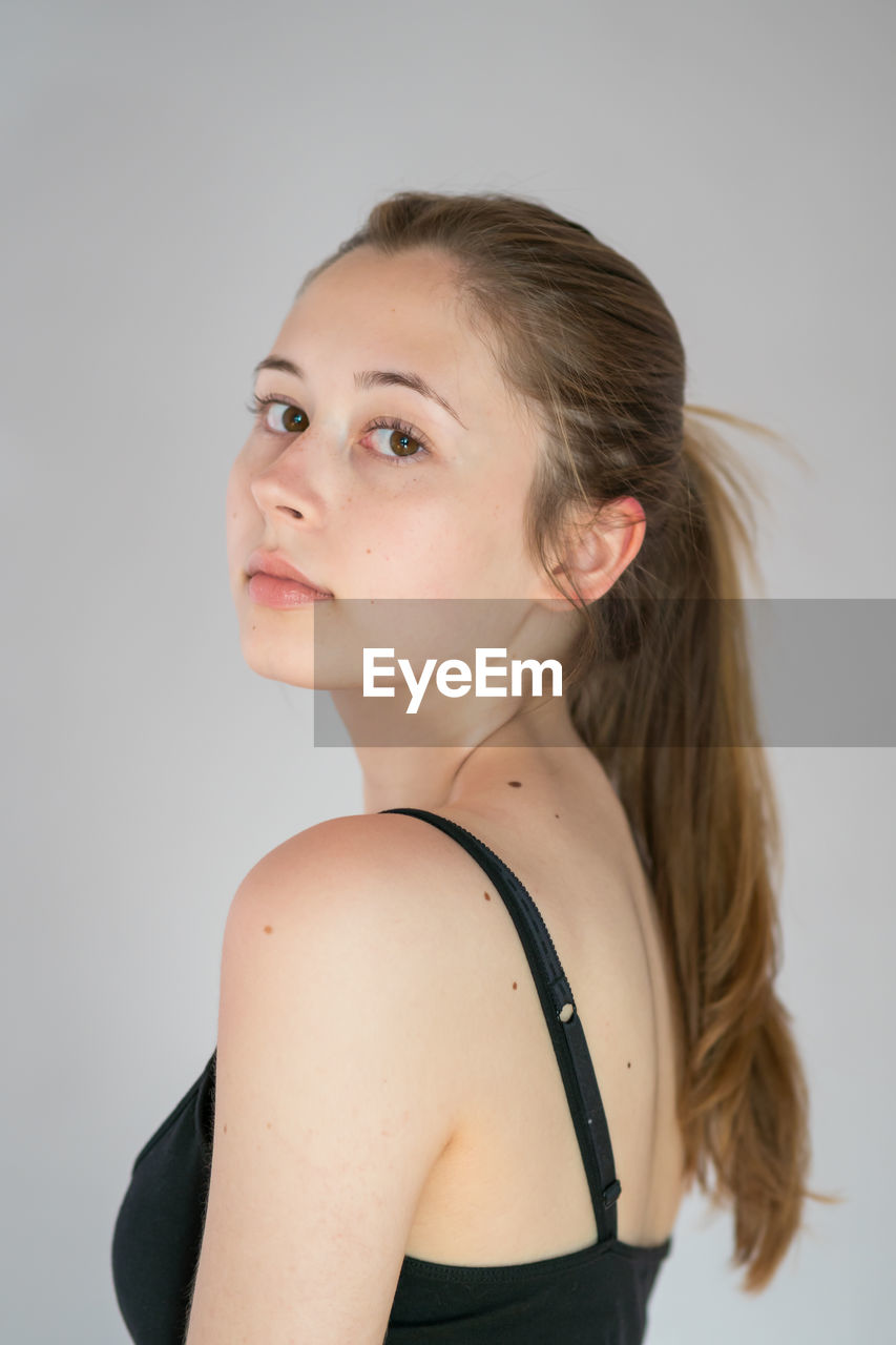 PORTRAIT OF WOMAN AGAINST WHITE BACKGROUND