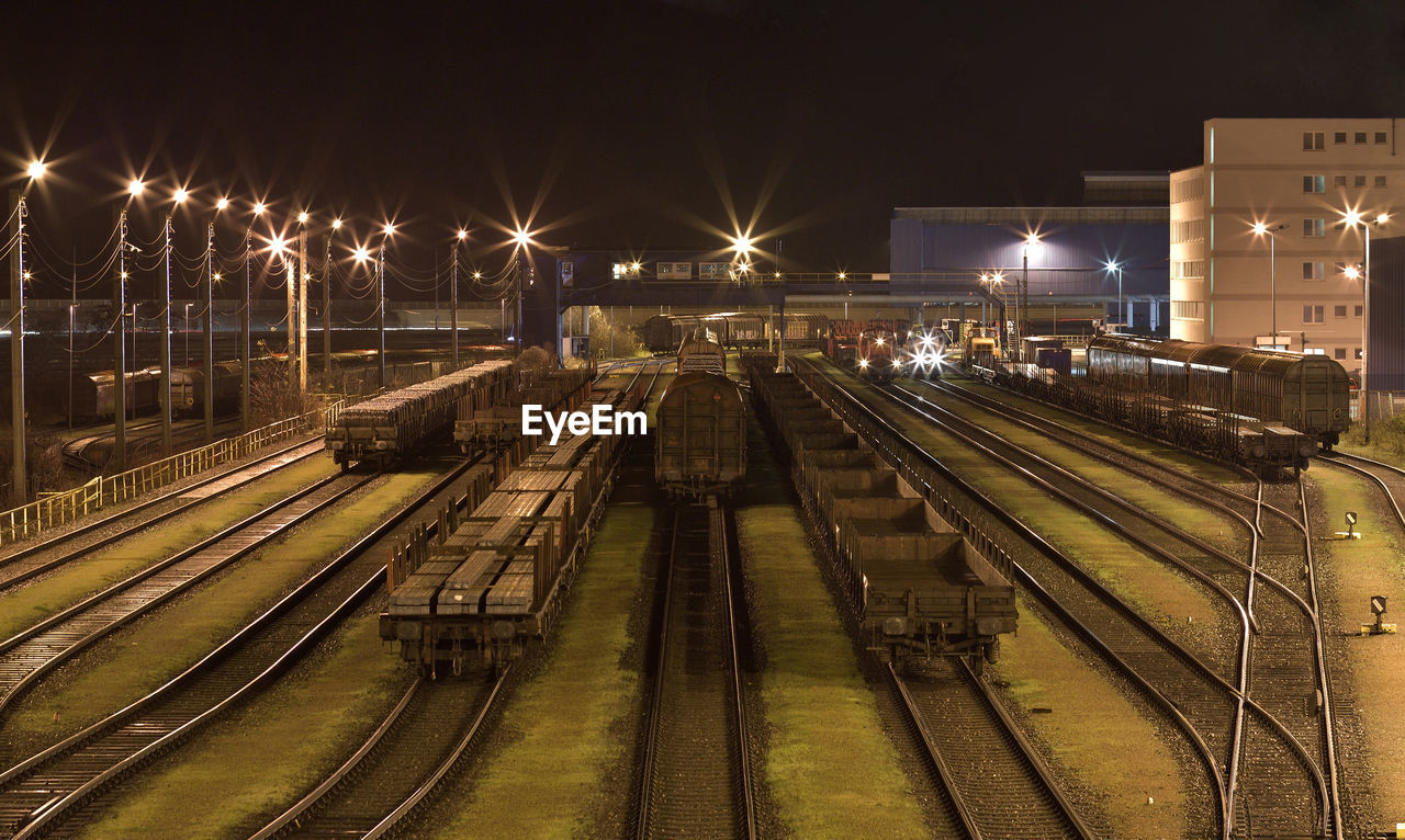 High angle view of trains on illuminated tracks at night