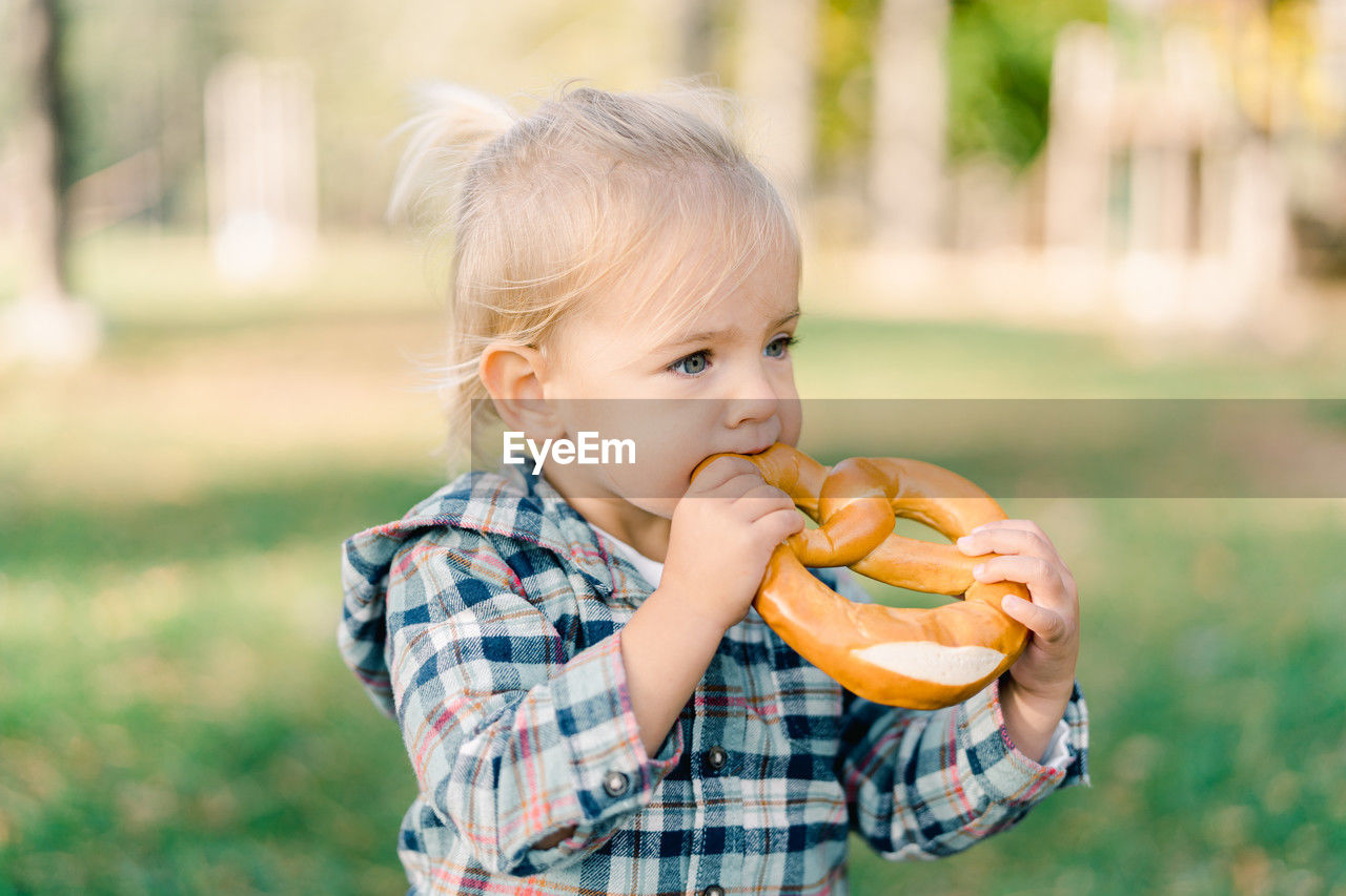 portrait of cute boy eating food at park