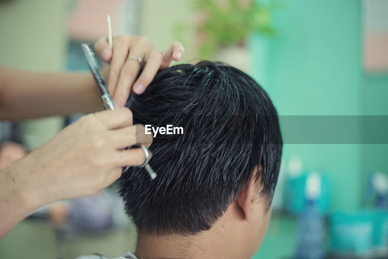 Close-up of man getting haircut