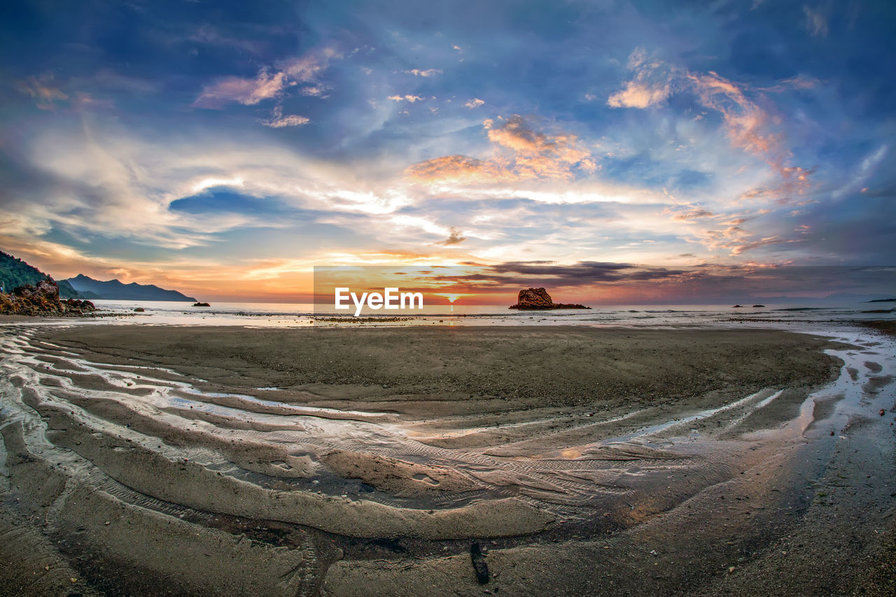 Scenic view of beach against sky during sunset