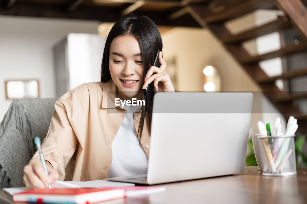 young woman using laptop while sitting at home