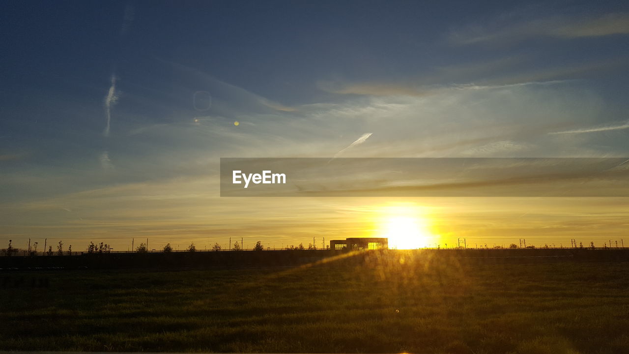 SCENIC VIEW OF FIELD AGAINST SKY AT SUNSET