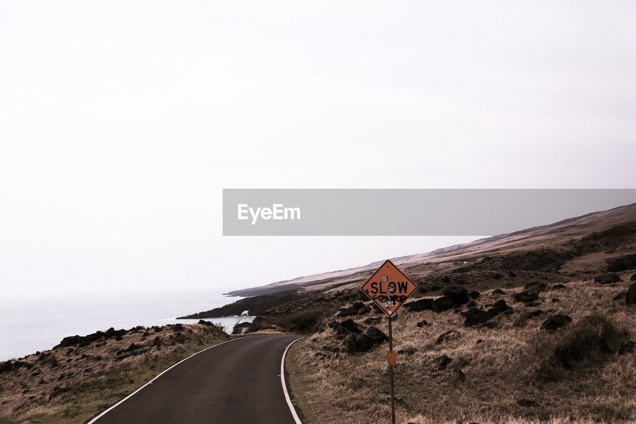 Road passing through landscape against clear sky