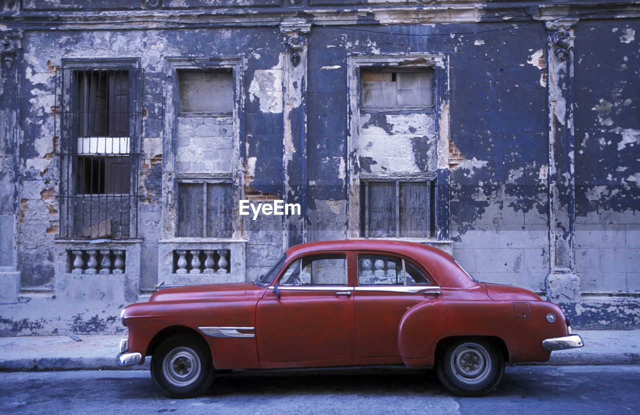 Red car against abandoned building