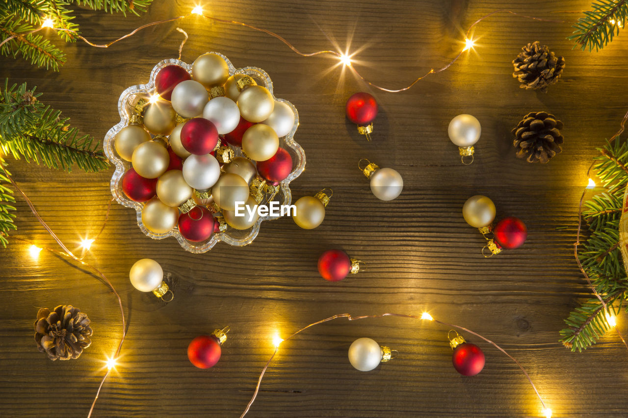 High angle view of illuminated christmas lights with decorations on wooden table