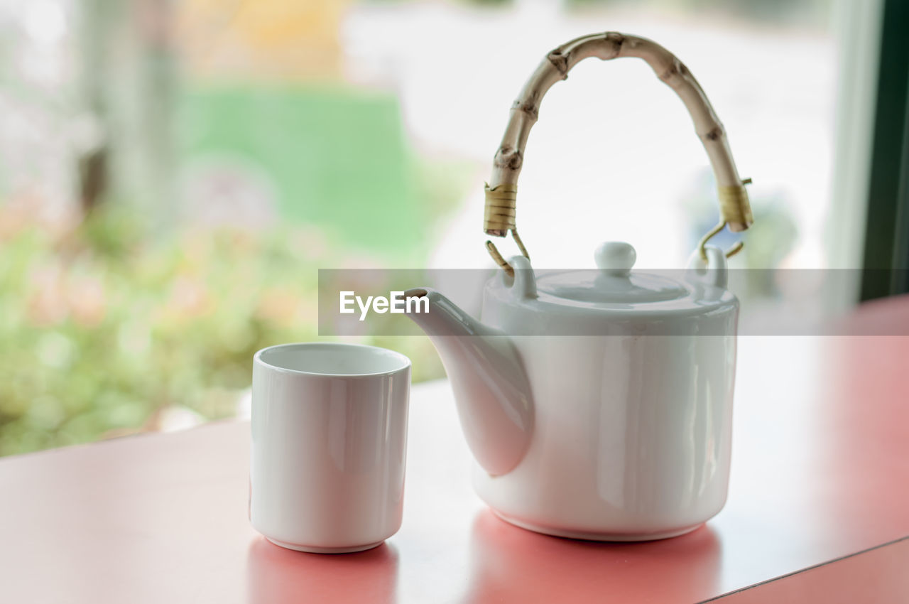 Close-up of teapot and cup on table